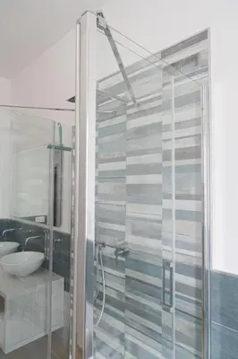 a bathroom with a glass shower and a sink at Light Charme, Natural Light Apartment a due passi dalla PIAZZA DUOMO in Terrasini