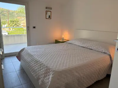 a bedroom with a bed and a door to a balcony at Luxury Hot tub Swimming pool Private pool Wi-Fi BBQ in Castellammare del Golfo