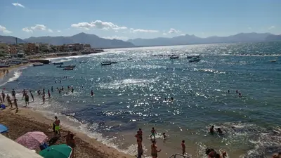 a group of people standing on a beach at Aspranthouse in Aspra