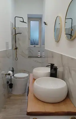 a bathroom with two sinks and a toilet and mirrors at CasaIniso' in Palermo