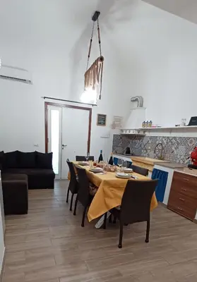 a kitchen and a dining room with a table and chairs at CasaIniso' in Palermo