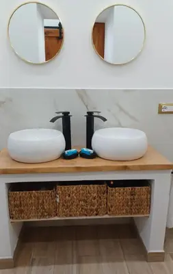 a bathroom vanity with a white sink and a mirror at CasaIniso' in Palermo