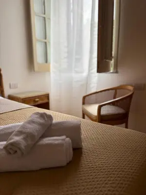 a towel on a bed in a hotel room at House La Cantinetta in Palermo