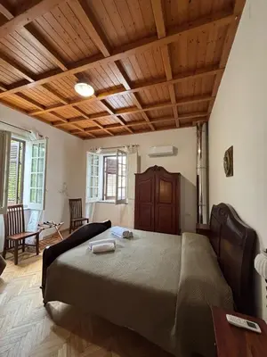 a bedroom with a large bed with a wooden ceiling at House La Cantinetta in Palermo