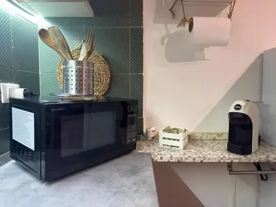 a microwave sitting on top of a counter in a kitchen at Emma's Beach Apartment in Isola delle Femmine