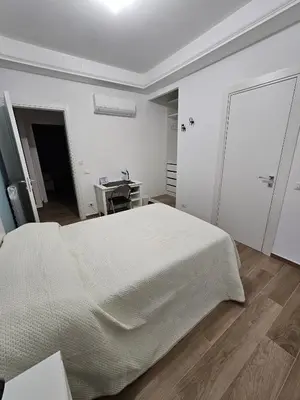 a white bedroom with a bed and a desk at Palermo Francia in Palermo