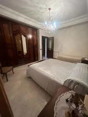 a bedroom with two beds and a chandelier at Rifugio panoramico in Montelepre
