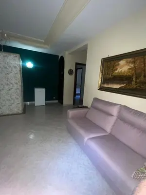 a living room with a couch and a painting on the wall at Rifugio panoramico in Montelepre