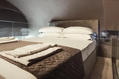 a bed with white pillows and towels on it at Cattedrale Suite in Palermo
