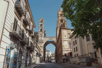 an arch in the middle of a street with two towers at Cattedrale Suite in Palermo