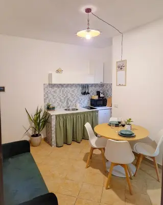 a living room with a table and a kitchen at Love nest cathedral ,in the heart of the city in Palermo