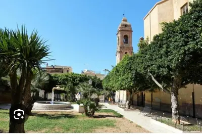 a city street with a clock tower in the background at Casa Monteserrato in Terrasini