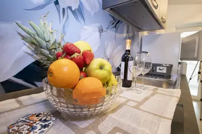 a bowl of fruit on a table with a bottle of wine at Villa degli Ulivi in Partinico