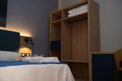 a bed with two white pillows in a room at Aurooms in Cinisi