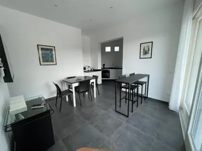 a living room with tables and chairs and a kitchen at Villa Tosto in Castelluzzo