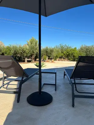 two chairs and a table with an umbrella at Villa Tosto in Castelluzzo