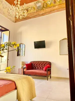 a living room with a red couch in a room at Palazzo 700 in Castellammare del Golfo