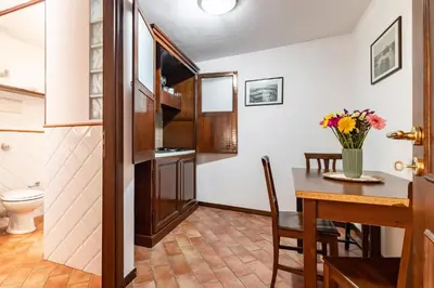 a kitchen and dining room with a table and a toilet at GuestHost - La Maison Real Palermo in Palermo