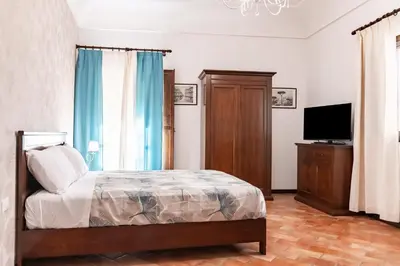 a bedroom with a bed and a flat screen tv at GuestHost - La Maison Real Palermo in Palermo