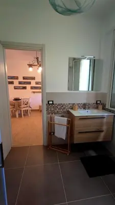 a bathroom with a sink and a mirror and a table at Heaven House Sicily in Carini