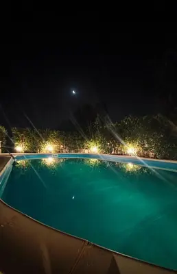 an empty swimming pool at night with lights at Heaven House Sicily in Carini