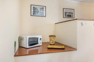 a microwave sitting on a shelf next to a refrigerator at GuestHost - Central Apartment Palermo in Palermo