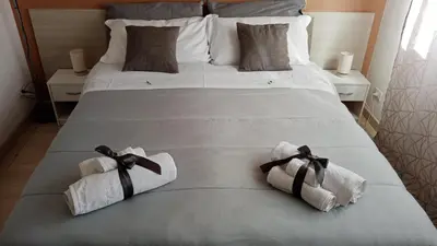 a large white bed with two towels on it at Dante091 in Palermo