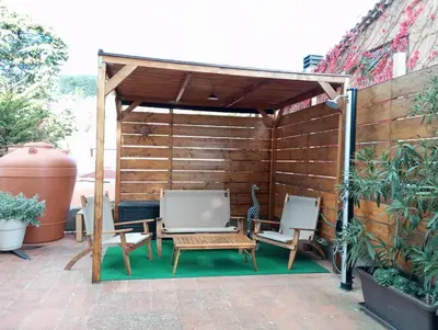 a wooden pergola with two chairs and a table at Mami house in Sambuca di Sicilia