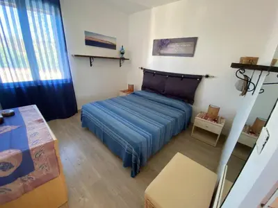 a bedroom with a blue bed in a room at Casa Bluet on the Sea in Balestrate