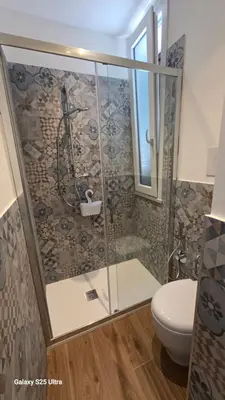 a bathroom with a glass shower with a toilet at Sichilia House in Palermo
