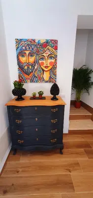 a painting of two women on a wall next to a dresser at Sichilia House in Palermo