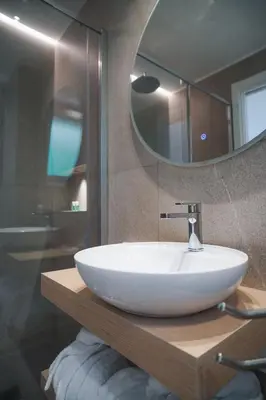 a bathroom with a white sink and a mirror at Regina Elena Luxury Apartments in Mondello