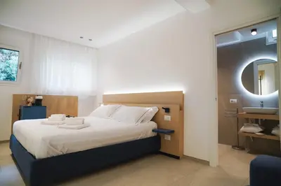 a bedroom with a large bed and a mirror at Regina Elena Luxury Apartments in Mondello