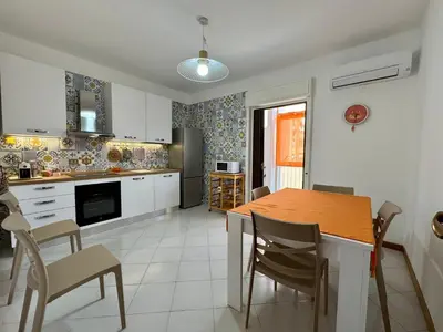 a kitchen with a table and chairs in a room at Castelforte House in Palermo