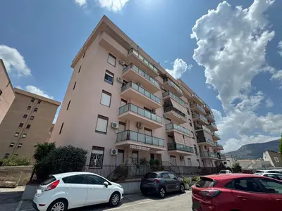 a tall building with cars parked in front of it at Castelforte House in Palermo