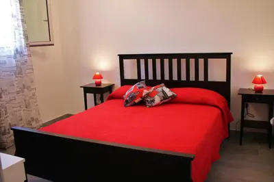 a red bed with two pillows on top of it at Baia del Sol Balestrate in Balestrate
