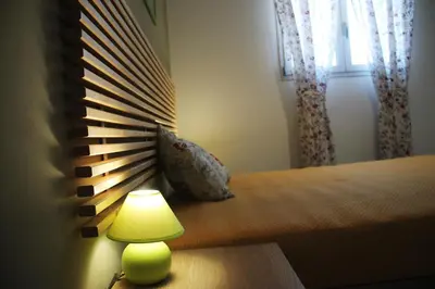 a bedroom with a bed with a lamp and a window at Baia del Sol Balestrate in Balestrate