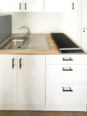 a kitchen with white cabinets and a sink at The Villa - Lascari Cefalu' in Lascari