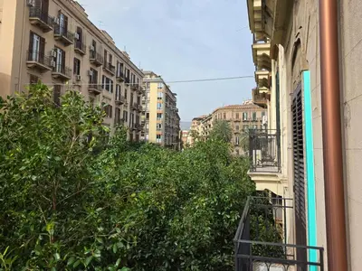 a city street with tall buildings and trees at Vivaldi Holidays Historic house in the center of Palermo in Palermo