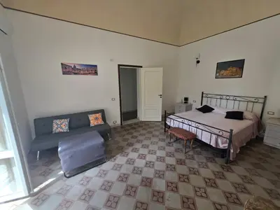 a bedroom with a bed with two night stands and two tables at Vivaldi Holidays Historic house in the center of Palermo in Palermo
