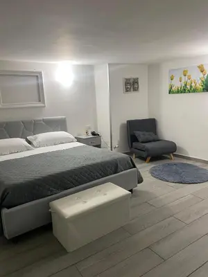 a bedroom with a large bed and a chair at La casetta dei Mori in Palermo