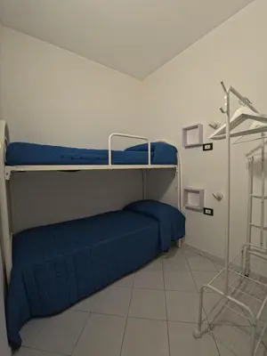 a bedroom with two bunk beds with blue sheets at Ciatu di Suli in San Vito lo Capo
