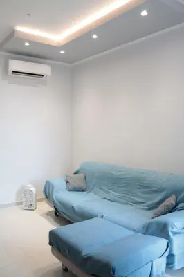 a living room with a blue couch in a room at Casa Totino Mondello in Palermo