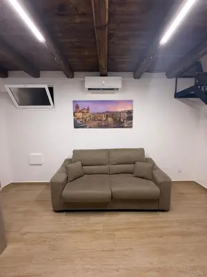 a living room with a brown couch in a room at La Dimora del CAPO in Palermo