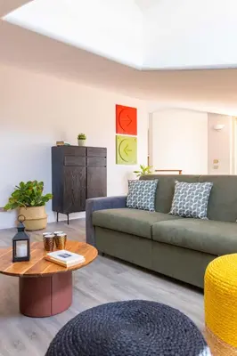 a living room with a green couch and a table at Apartment with 2 Terraces near Teatro Massimo in Palermo