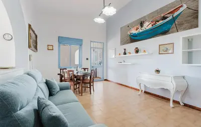 a living room with a blue couch and a table at Stunning Apartment In Balestrate in Balestrate