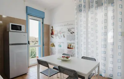 a kitchen with a white table and chairs and a refrigerator at Stunning Apartment In Balestrate in Balestrate
