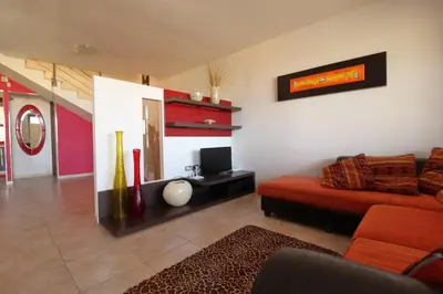 a living room with a red couch and a television at Villa Belorizzonte - Relax & Sea in Mandra Capreria