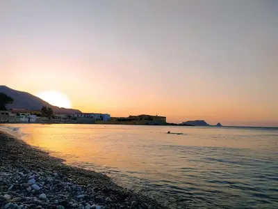 a sunset on a beach with the sun setting at Villa Belorizzonte - Relax & Sea in Mandra Capreria