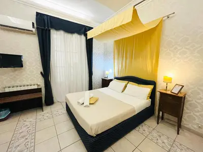 a bedroom with a bed with a yellow canopy at Antica Palermo R&B in Palermo